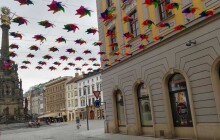 Nová výzdoba v ulici 28. října. Nad hlavou lidí visí duhové větrníky