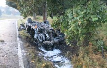 Řidič dostal na mokré silnici smyk a narazil do stromu. Auto se převrátilo na střechu a začalo hořet