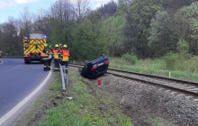 Auto na střeše v&nbsp;kolejišti. Drážní hasiči evakuovali 150 cestujících