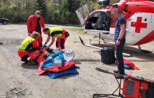 Pro zraněného turistu letěl vrtulník. Nesli ho k němu přes skály a stromy