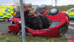 Auto na boku. Aby pomohli řidiči v bezvědomí, museli hasiči odstřihnout dveře