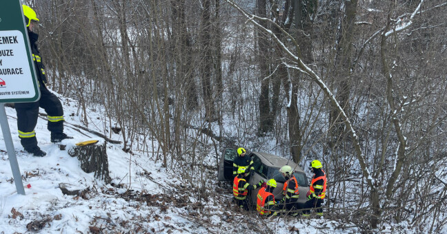 Auto uvězněné ve svahu i v potoce. Sníh zaměstnal řidiče i hasiče