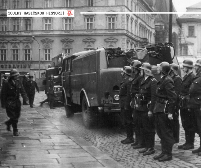 70. léta 20. století, Horní náměstí, Olomouc – Nástup družstva profesionálních olomouckých hasičů před radnicí na Horním náměstí při zahájení taktického cvičení. Všimnout si můžete i dobové techniky, a to konkrétně cisternové automobilové stříkačky ASC - 16 Škoda 706 RTH a automobilového žebříku na podvozku Tatra 148. | zdroj: HZS Olomouckého kraje
